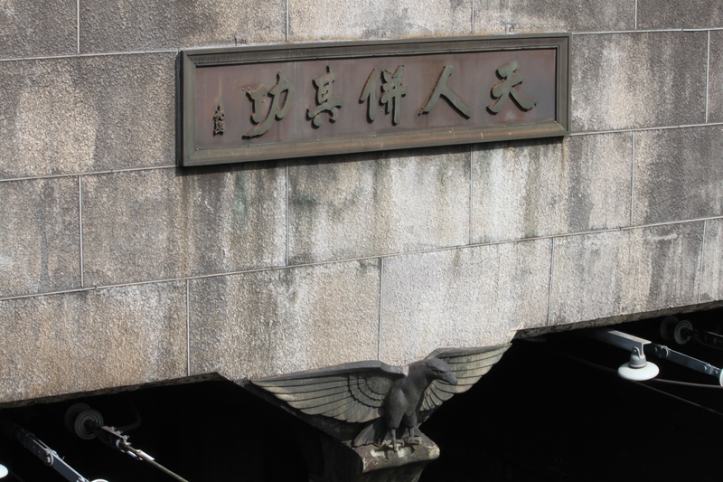入口に掲げられている「天人併其功」の銘板と鷲のレリーフ